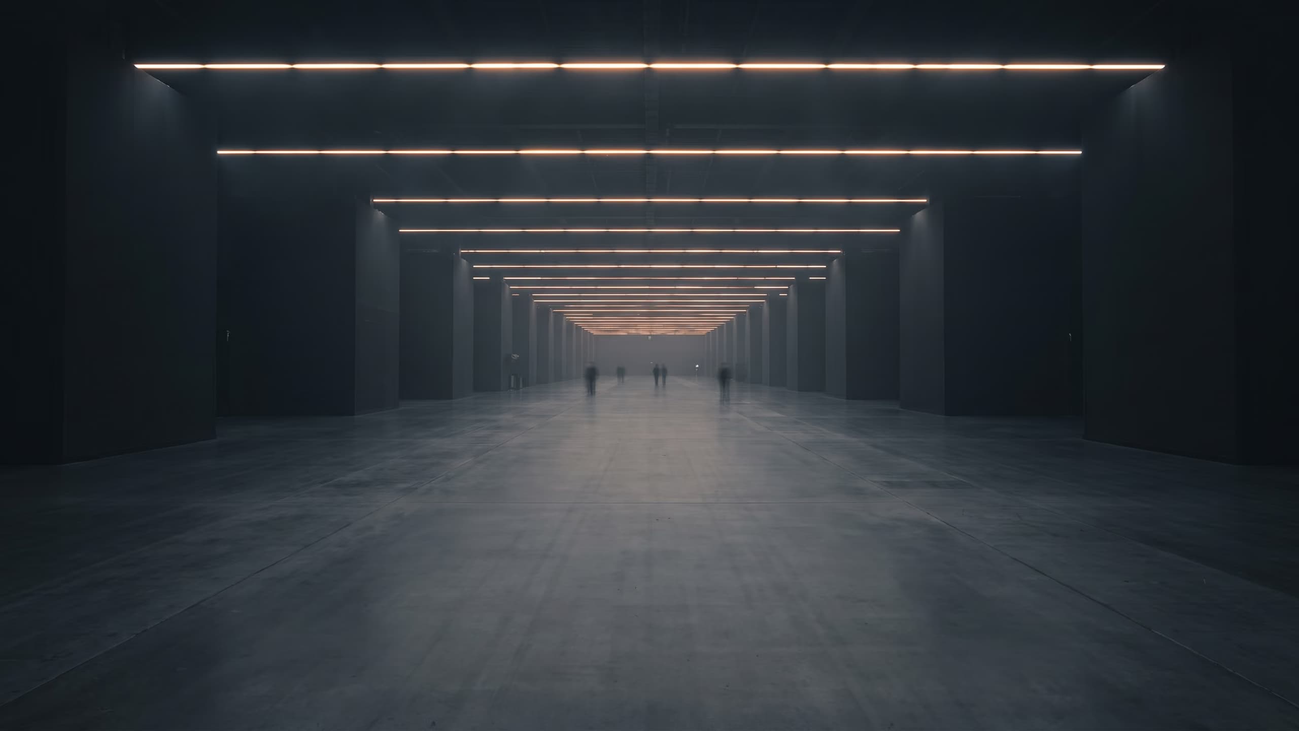 Eine Messehalle bei Nacht, von außen gesehen, mit beleuchteten Fensterbändern.