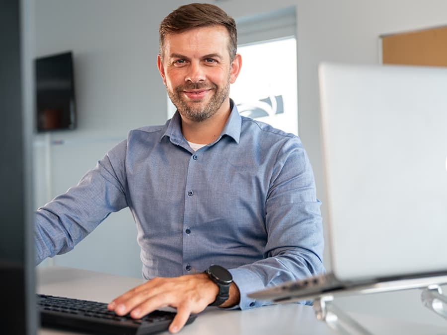 Ein Mitarbeiter des Vertriebsteams an seinem Arbeitsplatz.